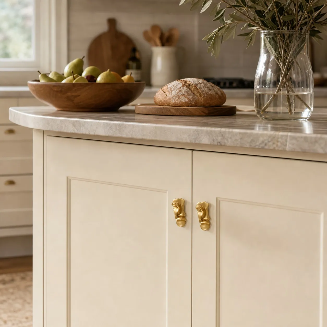 Pair of abstract brass face cabinet knobs on light kitchen cabinetry